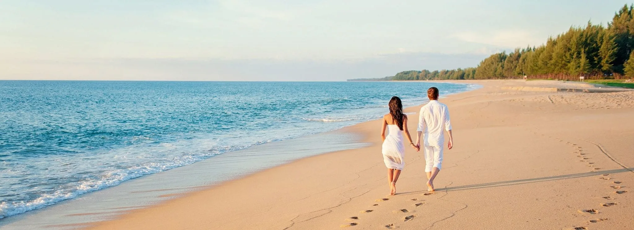 a couple is walking on the side of the beach coaster